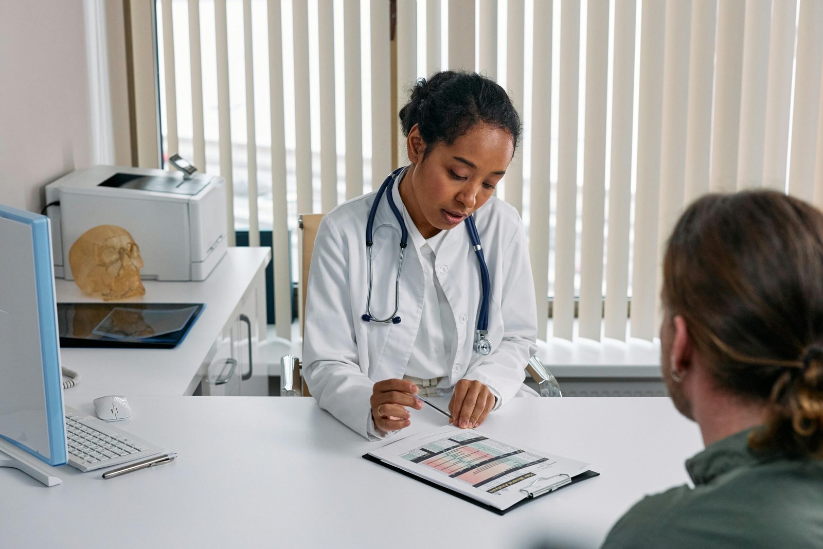 Products A doctor consulting with a patient in an office, discussing a medical chart.